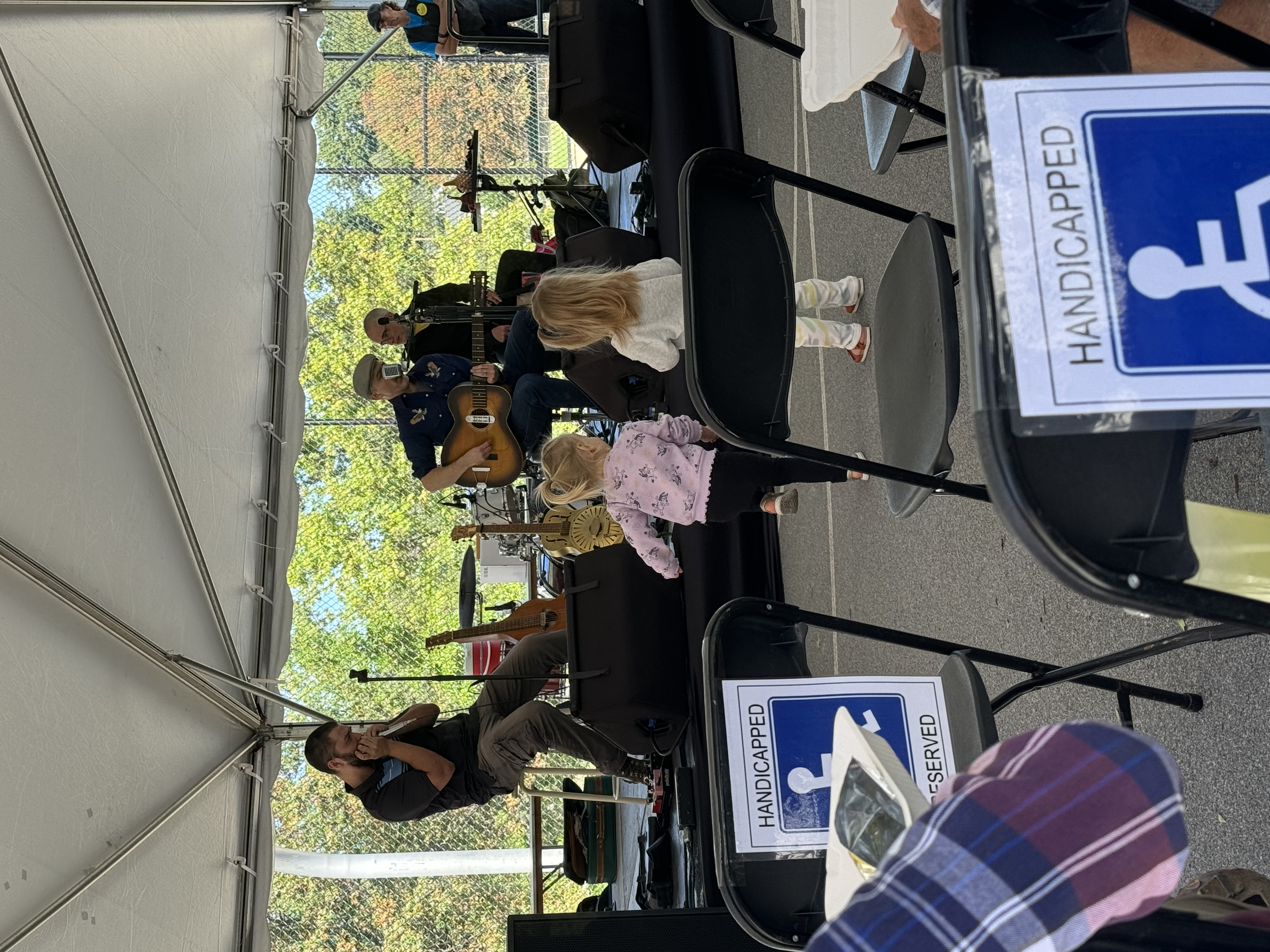 Outdoor community performance with accessible seating and multi-generational audience